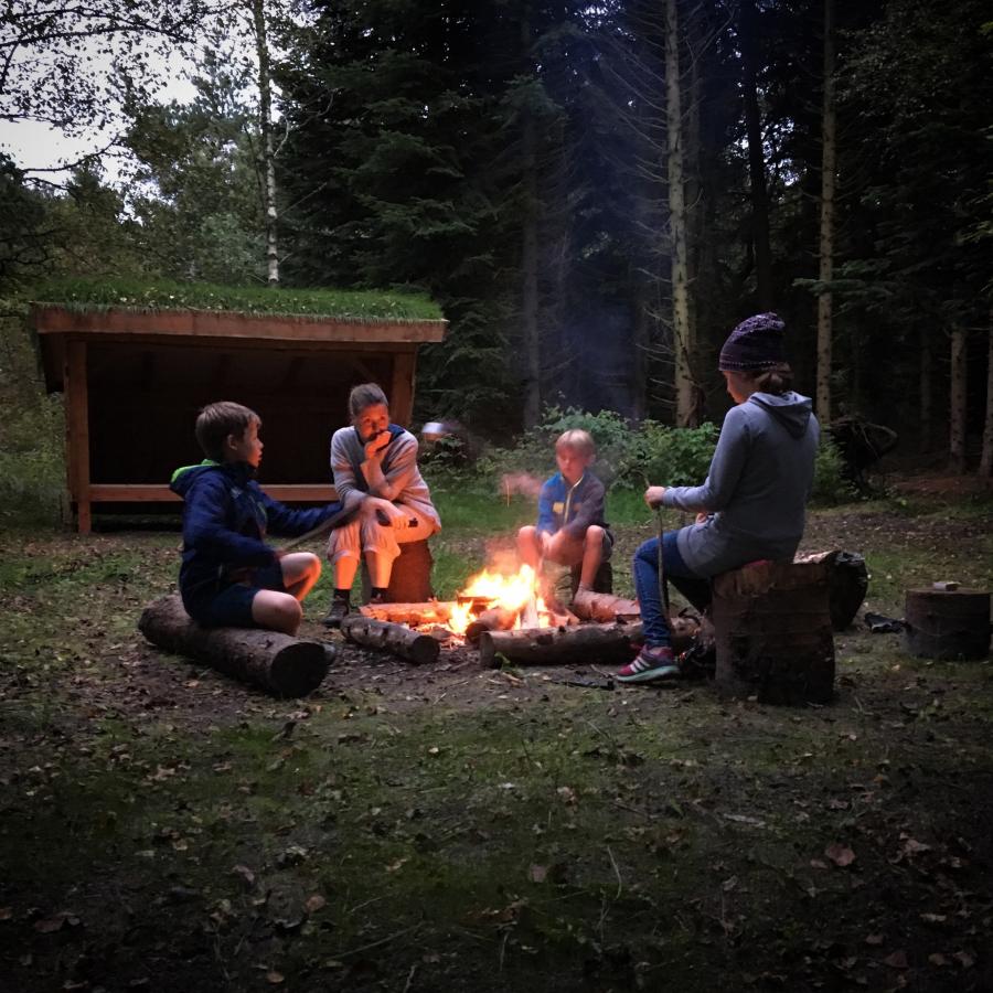Familie hygge ved bålsted og shelter